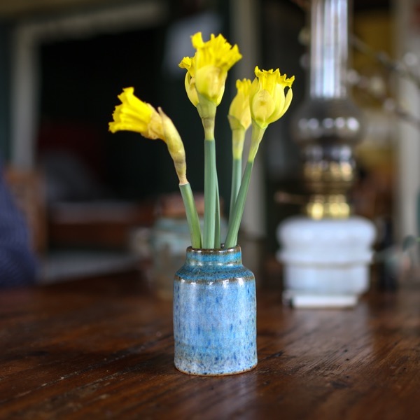 Foto van een vaas met narcissen uit de tuin op tafel